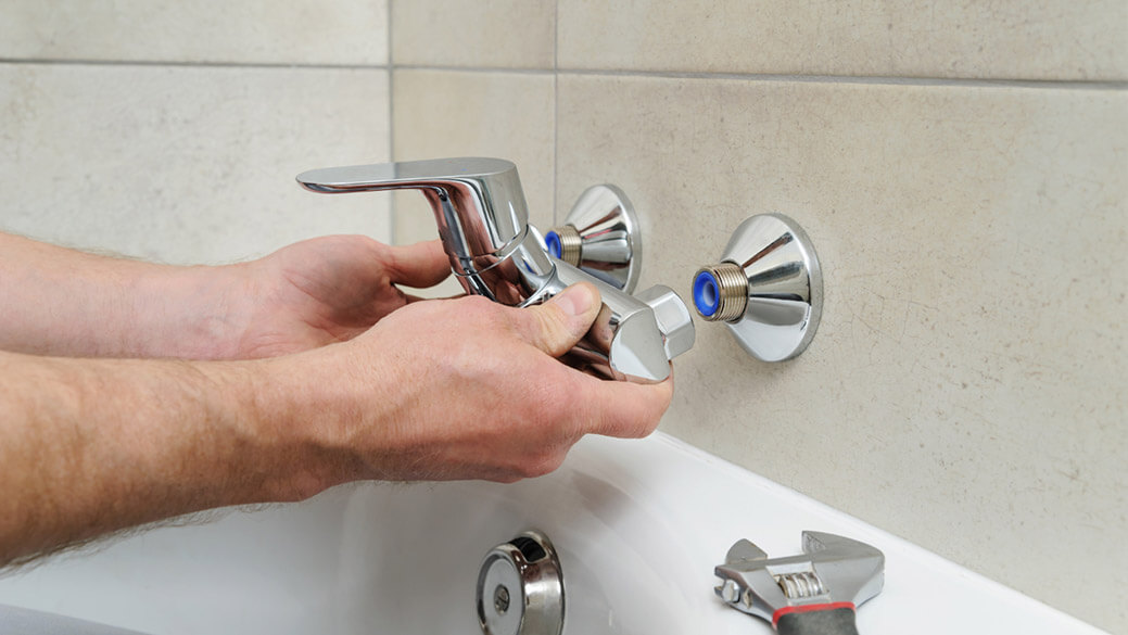 Plumber installing bathroom faucet