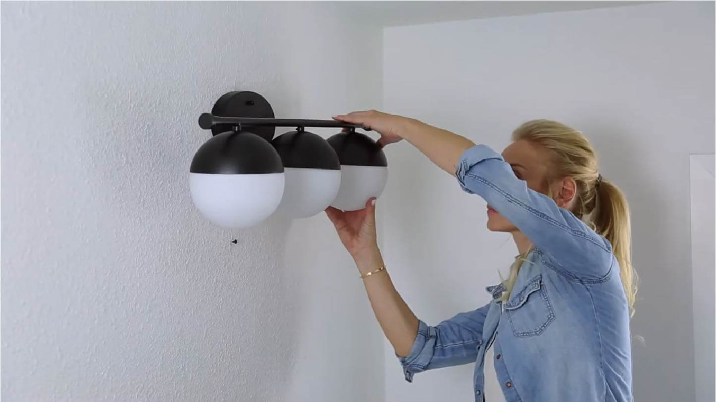 women changing bathroom lights bulb