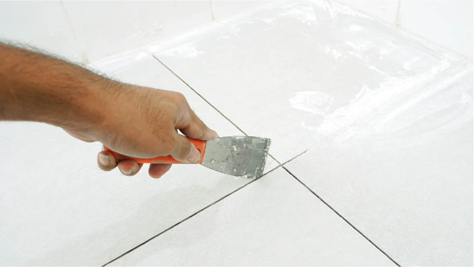 man repairing bathroom tiles