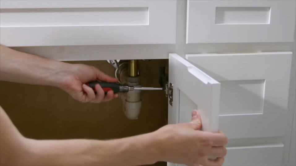 man disassembling the bathroom cabinets for paint